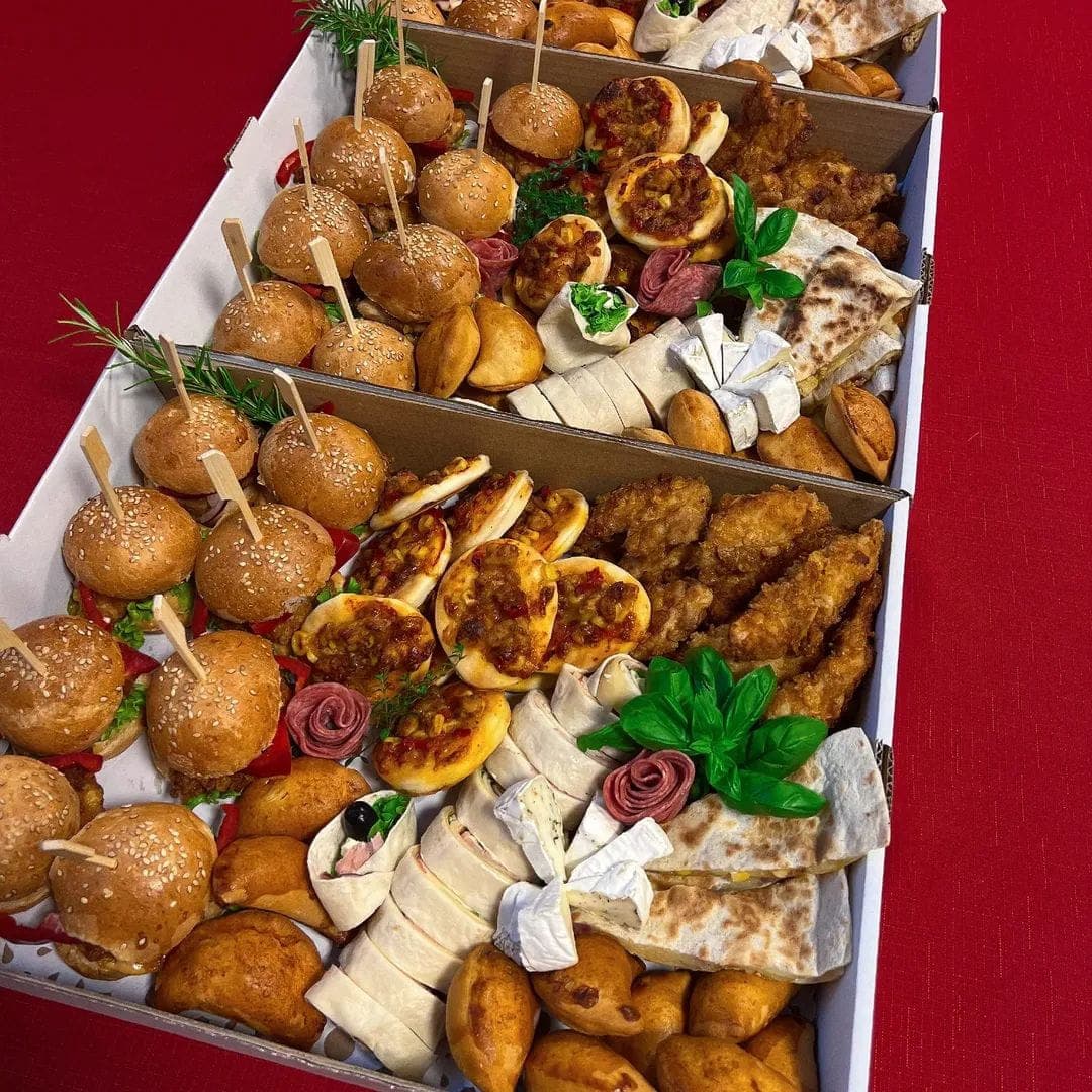 Pudełka cateringowe z przekąskami: mini burgery, pizzerinki, panierowane stripsy, roladki w tortilli i ser pleśniowy